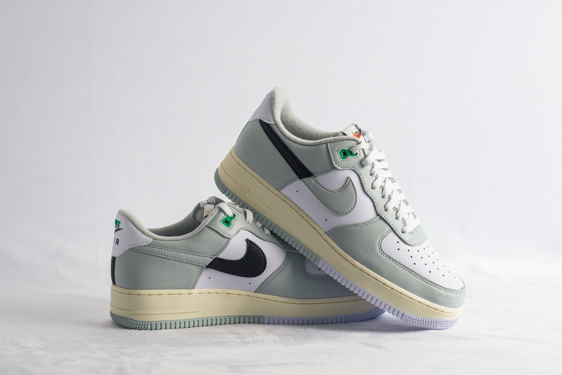 Nike Air Force 1 Sneaker in Pastellgrün und Weiß mit schwarzem Swoosh und cremefarbener Sohle