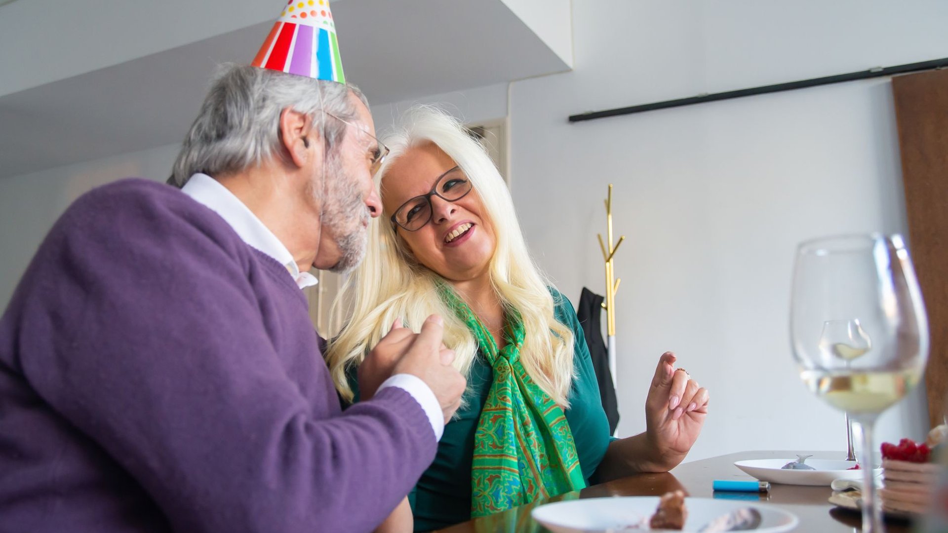 Älteres Paar feiert gemeinsam Geburtstag am Esstisch